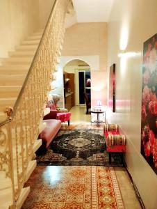 a living room with stairs and a rug at "Spirit of Malta" Historic Maltese Townhouse by the sea in Sliema