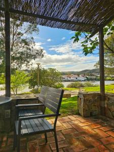 - un banc sur une terrasse avec une table et une vue dans l'établissement Casas Rurales Los Molinos, à Sanlúcar de Guadiana