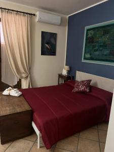 a bedroom with a large bed with a red blanket at B&B Marilù in Mercato San Severino