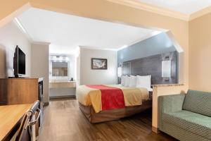 ein Hotelzimmer mit einem Bett und einem Stuhl in der Unterkunft Econo Lodge Byron - Warner Robins in Byron