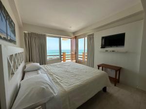 een slaapkamer met een bed en uitzicht op de oceaan bij Bungalows Playa Bonita in Máncora