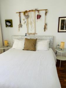 een slaapkamer met een wit bed met witte kussens bij Sweet Atic in Sitges