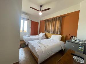 Habitación de hotel con 2 camas y ventilador de techo. en Adriatica Hotel Marsa Matrouh, en Marsa Matruh 28 fotos más