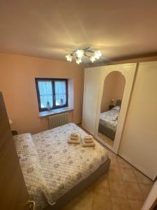 1 dormitorio con cama y espejo grande en Ca' Degli Olivi. Relax Lunigiana, en Agnino