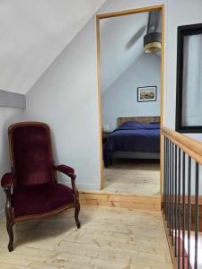 Habitación con silla, cama y espejo. en Gite au pied de la Colline en Vézelay