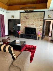 a living room with a couch and a fireplace at Lris villas in Phuket Town