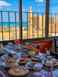 una mesa con comida y vistas a la ciudad en Adriatica Hotel Marsa Matrouh, en Marsa Matruh