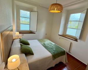 a bedroom with a large bed with green pillows at Apartamentos Santa Marina in Llanes