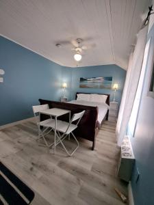 1 dormitorio con cama, mesa y sidx sidx sidx de mesa en Windspire Inn, en Port Elgin
