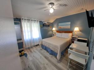 1 dormitorio con 1 cama y ventilador de techo en Windspire Inn, en Port Elgin