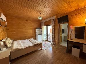 a bedroom with a bed and a wooden wall at Palm Konak Hotel in Cıralı