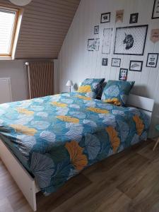 1 dormitorio con 1 cama grande y edredón colorido en Les Hirondelles du MAMBOURG, en Sigolsheim