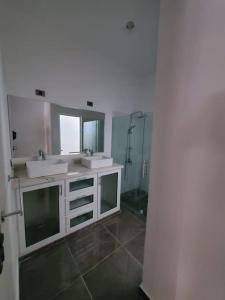 La salle de bains est pourvue de 2 lavabos et d'une douche. dans l'établissement La casa blanca, à Río San Juan