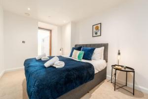 a bedroom with a large bed with a blue blanket at In the heart of Cardiff City Centre in Cardiff