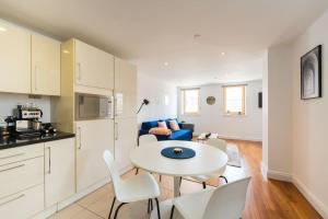 a kitchen and living room with a white table and chairs at In the heart of Cardiff City Centre in Cardiff