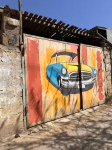 a wall with a painting of a car on it at Sovet Hostel in Baku