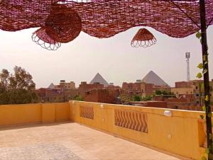 four pyramids Guest house في القاهرة: اطلالة على الاهرامات من شرفة المبنى