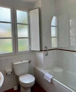 a bathroom with a toilet and a tub and a sink at Apartamentos Santa Marina in Llanes