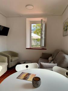 ein Wohnzimmer mit einem Sofa und einem Tisch in der Unterkunft Apartamentos Santa Marina in Llanes