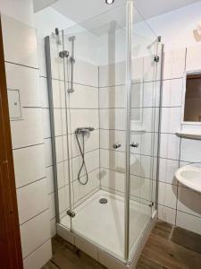 a shower with a glass door in a bathroom at Hotel Neo Cologne Bonn Airport in Rösrath