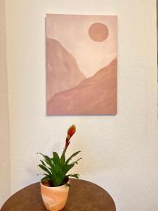 a plant sitting on a table next to a painting at Hotel Neo Cologne Bonn Airport in Rösrath