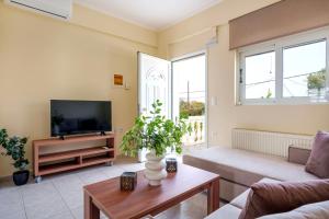 a living room with a couch and a tv at Solomos Apartments in Skala