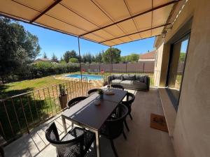 a patio with a table and chairs on a balcony at Villa en Provence in Saint-Saturnin-les-Apt
