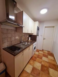 a small kitchen with white cabinets and a sink at Max's downtown oasis in Zadar +10 photos