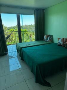 - une chambre avec 2 lits et une grande fenêtre dans l'établissement Casa de Vidro Sairé, à Récife