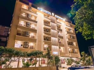 Un edificio alto con coches aparcados delante. en Adriatica Hotel Marsa Matrouh, en Marsa Matruh