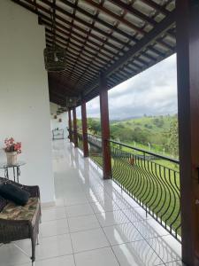 um quarto com uma varanda com vista para um campo em Casa de Vidro Sairé no Recife