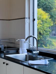 encimera de cocina con fregadero y ventana en Casa Country Altos Arrayanes, en Mercedes