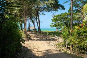 a dirt road with trees and the ocean in the background at Villa Jaymar in Arboletes