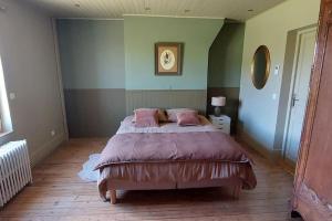 a bedroom with a large bed with pink pillows at Maison de maître avec piscine in Quetteville +28 photos