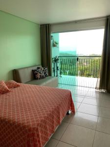 - une chambre avec un lit et une vue sur un balcon dans l'établissement Casa de Vidro Sairé, à Récife