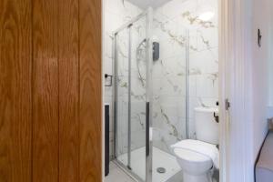 uma casa de banho com um WC e uma cabina de duche em vidro. em Serene Earlsdon Flat With Smart TV, Wifi & 10 Minute walk to Train Station em Spon End