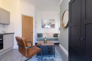 uma sala de estar com uma cadeira e um sofá em Serene Earlsdon Flat With Smart TV, Wifi & 10 Minute walk to Train Station em Spon End