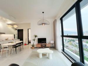 a living room with a large window and a dining table at Urban Suites Georgetown New Condo City View 158 in Jelutong