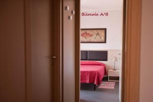 サン・バルトロメーオ・アル・マーレにあるAppartamenti Lindaの赤いベッド付きのベッドルーム1室の景色を望めます。