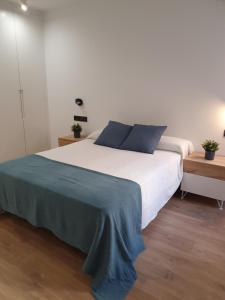 a bedroom with a large white bed with blue pillows at LaRambla Alicante City 3 Bdrm in Alicante