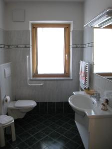 a bathroom with a white toilet and a sink at Garni Mozart Nesthouse in Canazei