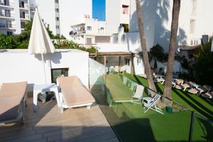 a patio with two chairs and a table and umbrella at Hotel Tarba in San Antonio +163 photos