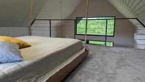 a large bed in a room with a window at Barnhouse "Family Estate" in Kamianets-Podilskyi