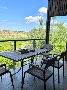 - une table et des chaises en bois sur une terrasse couverte avec vue dans l'établissement Barnhouse "Family Estate", à Kamianets-Podilsky