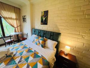 een slaapkamer met een bed en een bakstenen muur bij Bubucoca Residence in Baños