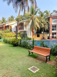 a park bench sitting in front of a house at Luxury apartment Blue lagoon in Goa