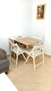 una mesa de madera y sillas en una habitación en Sol Centro Apartment A, en Sevilla