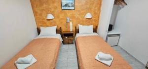 two beds in a small room with at Hotel Palladion in Karterados