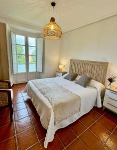 a bedroom with a large bed and a chandelier at Apartamentos Santa Marina in Llanes