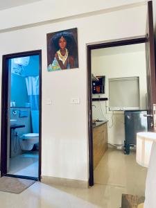 a room with a bathroom with a television and a mirror at Luxury apartment Blue lagoon in Goa